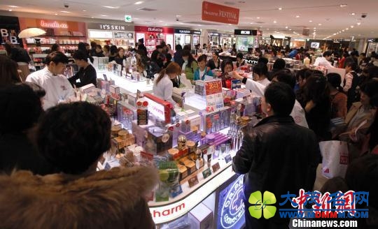资料图：韩国一家免税店的化妆品柜台前人头攒头，不少柜台能以人民币直接结算。中新社发 刘关关 摄