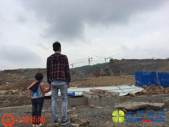王亮兄妹俩站在自家被拆迁的房屋前，这里已是一片废墟。上游新闻记者 张曼双 摄